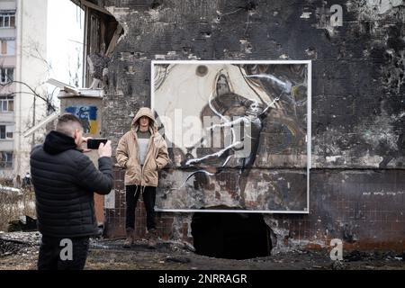 Irpin, Ukraine. 25. Februar 2023. Irpin, Ukraine - 25. Februar 2023: Kunstwerk des weltbekannten Graffiti-Künstlers Banksy an der Mauer eines zerstörten Gebäudes im ukrainischen Dorf Irpin, das durch die Kämpfe in den frühen Tagen der russischen Invasion schwer beschädigt wurde. (Foto: Kish Kim/Sipa USA) *** Korea out *** Kredit: SIPA USA/Alamy Live News Stockfoto