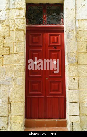 Traditionelle, klassische, mittelalterliche, rotbemalte Holztür im Valletta, Malta. Stockfoto