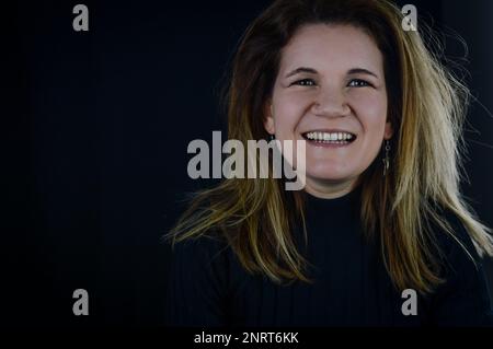 Porträt einer schönen blonden Frau, die fröhlich lacht, spontan und ehrlich Stockfoto