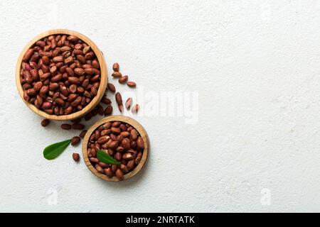 Frische, gesunde Erdnüsse in der Schüssel auf farbigem Tischhintergrund. Top View gesunde Ernährung bertholletia Konzept. Super Essen. Stockfoto