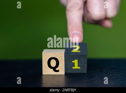 Symbol für das 2. Quartal des Jahres. Die Hand dreht Würfel und ändert den Ausdruck Q1 in Q2. Stockfoto