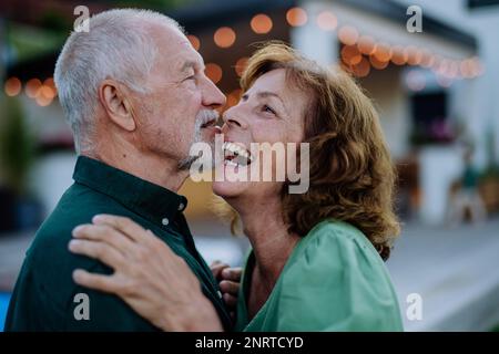 Seniorin und Seniorin tanzen im Sommer zusammen in einem Garten. Stockfoto