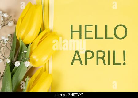 Hallo April - Frühlings-Postkarte mit gelben Tulpen und Text Stockfoto