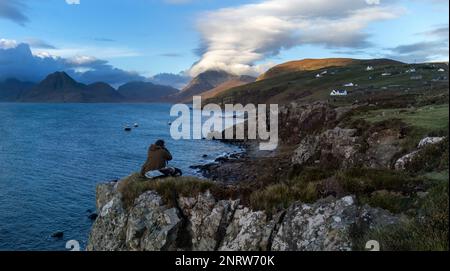 Ein Fotograf fotografiert nordwestlich über Loch Scavaig in Richtung Cuillin Mountain Range im Dorf Elgol auf der Insel Skye. Stockfoto