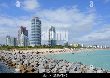 Blick auf Wolkenkratzer, South Pointe Park Pier und South Beach mit Sonnenanbetern, die Sonne, Strand und Atlantik genießen. Miami, Florida Stockfoto