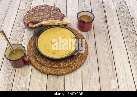 Typisch mexikanischer Eintopf mit Kürbisblütenhähnchen in einer Metallpfanne mit Weizentortillas für Burritos Stockfoto