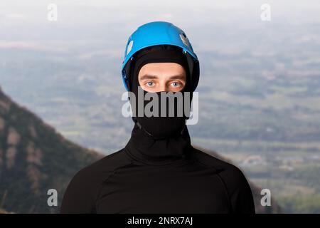 Mann, Tourist, Kletterer. In einem Helm, Schutzhelm. In den Bergen. Höhe. Stockfoto