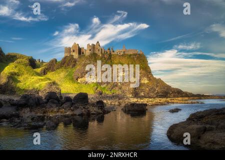 Blick von einer Küste auf Dunluce Castle am Rand der Klippe, Teil des Wild Atlantic Way, Nordirland. Drehort einer beliebten Fernsehsendung Stockfoto