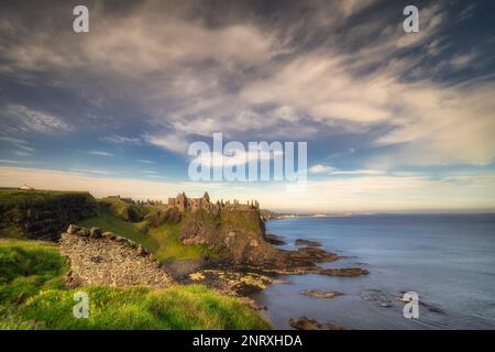 Ruinen von Dunluce Castle am Rand der Klippe, von der kleinen Mauer aus gesehen, Bushmills, Nordirland. Drehort einer beliebten Fernsehsendung Stockfoto