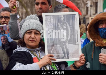 London, Großbritannien. 27. Februar 2023 Ein Demonstrante hat ein Foto von Reza Shah. Anhänger von Reza Pahlavi, dem Kronprinzen des Iran, versammelten sich auf dem Parlamentsplatz, als er das Unterhaus besuchte, um über die Zukunft des Iran zu diskutieren. Kredit: Vuk Valcic/Alamy Live News Stockfoto