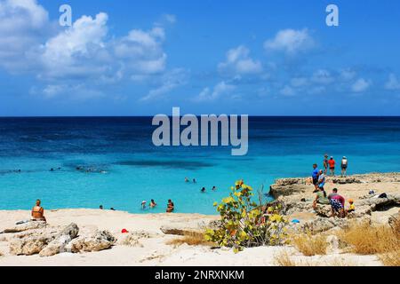 Tres Trapi Beach, Noord, Aruba - 10. März 2022. Menschen am Strand und im Wasser, Strand ist umgeben von einer vulkanischen Felsformation. Stockfoto