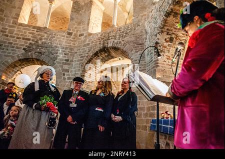 Man sieht eine Frau, die darüber redet, wie sich das Paar während einer vorgetäuschten, aber lustigen Begegnung getroffen hat. Die Tradition der falschen Bauernhochzeit während des Karnevals reicht bis ins 16. Jahrhundert zurück, der Adel spielte die Rolle der Bauern und die Bauern waren die Lords. In Nijmegen waren Anja und Theo Wijlemans dieses Jahr das Hochzeitspaar des Bauern. Das Paar versammelte sich in der Valkhof-Kapelle, trug traditionelle Bauernkleidung und war umgeben von Menschen in lebhaften Kostümen. Die Hochzeit des Bauern ist eine der niederländischen Karnevalstraditionen, insbesondere in Limburg, Nordbrabant und Gelderland. Die Umkehrung Stockfoto