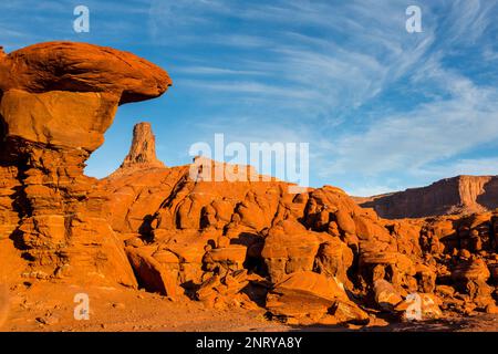 Ein Wingate Sandstone butte, eingerahmt von einer gestreiften Cutler Sandstein Felsformation am Shafer Trail bei Moab, Utah. Die weißen Streifen werden als "t" bezeichnet Stockfoto