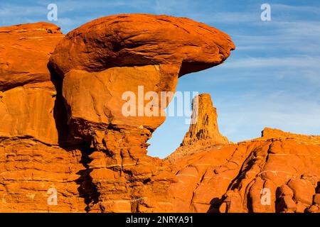 Ein Wingate Sandstone butte, eingerahmt von einer gestreiften Cutler Sandstein Felsformation am Shafer Trail bei Moab, Utah. Die weißen Streifen werden als "t" bezeichnet Stockfoto