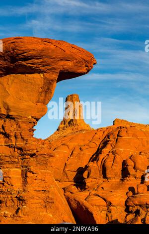 Ein Wingate Sandstone butte, eingerahmt von einer gestreiften Cutler Sandstein Felsformation am Shafer Trail bei Moab, Utah. Die weißen Streifen werden als "t" bezeichnet Stockfoto