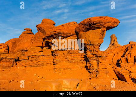 Ein Wingate Sandstone butte, eingerahmt von einer gestreiften Cutler Sandstein Felsformation am Shafer Trail bei Moab, Utah. Die weißen Streifen werden als "t" bezeichnet Stockfoto