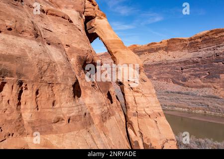 Aus der Vogelperspektive bietet sich der Jug Handle Arch an, ein fast vertikaler Bogen aus Wingate Sandstein am Colorado River bei Moab, Utah. Der Bogen ist auf der Lower Colorado Ri Stockfoto