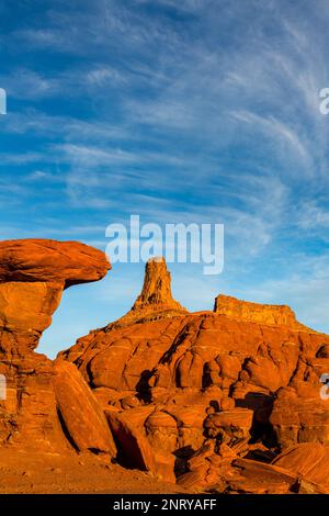 Ein Wingate Sandstone butte mit gestreiften Cutler Sandstein Felsformationen vor dem Shafer Trail bei Moab, Utah. Aber die weißen Streifen sind es Stockfoto