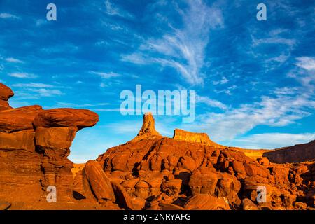 Ein Wingate Sandstone butte mit gestreiften Cutler Sandstein Felsformationen vor dem Shafer Trail bei Moab, Utah. Aber die weißen Streifen sind es Stockfoto