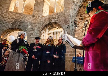 Nijmegen, Niederlande. 21. Februar 2023. Man sieht eine Frau, die darüber redet, wie sich das Paar während einer vorgetäuschten, aber lustigen Begegnung getroffen hat. Die Tradition der falschen Bauernhochzeit während des Karnevals reicht bis ins 16. Jahrhundert zurück, der Adel spielte die Rolle der Bauern und die Bauern waren die Lords. In Nijmegen waren Anja und Theo Wijlemans dieses Jahr das Hochzeitspaar des Bauern. Das Paar versammelte sich in der Valkhof-Kapelle, trug traditionelle Bauernkleidung und war umgeben von Menschen in lebhaften Kostümen. Die Hochzeit des Bauern ist eine der niederländischen Karnevalstraditionen, insbesondere in Limburg, N Stockfoto