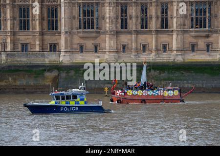 Westminster, London, Großbritannien. 27. Februar 2023. Aussterbende Rebellion und Umweltschützer veranstalteten heute in Westminster eine Protestveranstaltung gegen die Umweltverschmutzung durch die britischen Wasserstraßen. Die Demonstranten in einem Wikingerboot passierten den Westminster-Palast entlang der Themse mit einem riesigen Banner, auf dem englisches Erbe steht. United Kingdom Parliament, Facilitation the degradation of water 1706-2063. Umweltschützer fordern die Regierung auf, die öffentliche Gesundheit und die biologische Vielfalt gesetzlich zu schützen und Wasserunternehmen daran zu hindern, Abwässer in unsere Flüsse und Meere abzuleiten. So wie es aussieht, dürfen sie weiterhin di durchführen Stockfoto