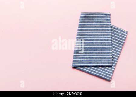 Blick von oben mit blauer Serviette auf Tischhintergrund isoliert. Gefaltetes Tuch für Modell mit Kopierbereich, flach liegend. Minimalistischer Style. Stockfoto