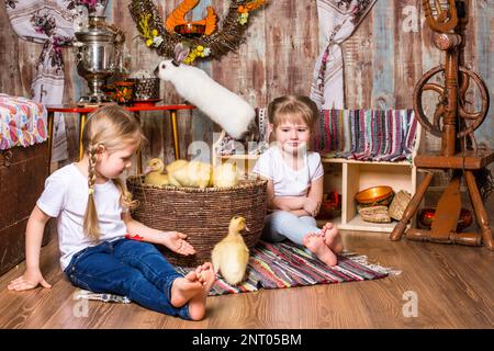 Glückliche kleine Mädchen werden mit süßen flauschigen osterentchen gespielt Stockfoto