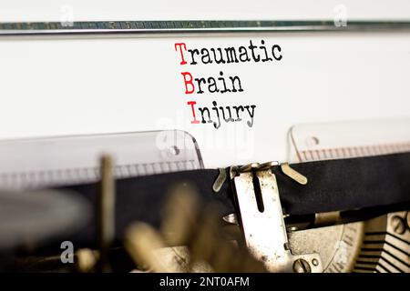 TBI-Symbol für Schädel-Hirn-Trauma. Konzeptbegriffe TBI traumatische Hirnverletzung, getippt auf einer alten Schreibmaschine auf einem schönen weißen Papierhintergrund. Sanitäter Stockfoto