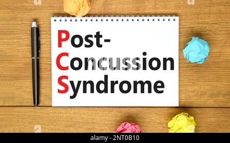 PCS-Postconcussion-Syndrom-Symbol. Konzeptbegriffe PCS-Postconcussion-Syndrom auf weißer Note auf einem schönen Holzhintergrund. Medizin und PCS post-c Stockfoto