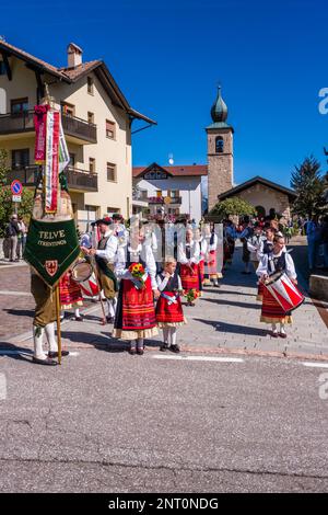 Traditionell gekleidete Leute spielen Musik während des Almabtriebs, dem Viehtrieb von der Bergweide, im Dorf Fai della Paganella. Stockfoto