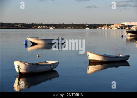 Drei kleine Boote am Strand bei Sonnenuntergang Stockfoto