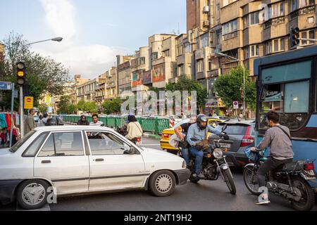 Motorräder quetschen durch den versperrten Verkehr und blockieren eine belebte Kreuzung im zentralen Iran. Stockfoto