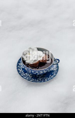 Heiße Schokolade in blau-weißer japanischer Teetasse und Untertasse mit Baiser im Schnee Stockfoto