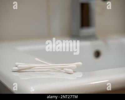 Wattestäbchen in den Ohren auf weißem Hintergrund. Stockfoto