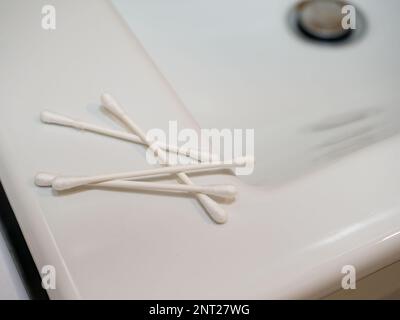 Wattestäbchen in den Ohren auf weißem Hintergrund. Stockfoto