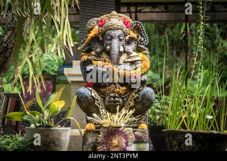 Ganesh-Statue mit Floweers in einem Tempel in Ubud, Bali, Indonesien. Spirituelles Kulturkonzept Stockfoto