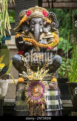 Ganesh-Statue mit Floweers in einem Tempel in Ubud, Bali, Indonesien. Spirituelles Kulturkonzept Stockfoto