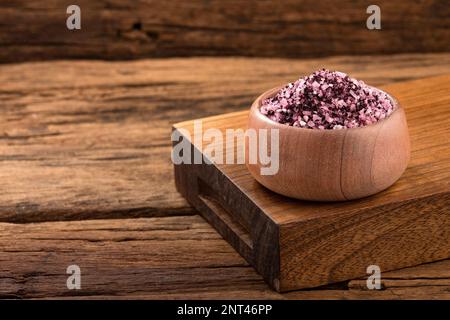 Hibiskus-Salzkristalle in der Holzschüssel - Würzmittel zum Aromatisieren und Würzen von Speisen Stockfoto