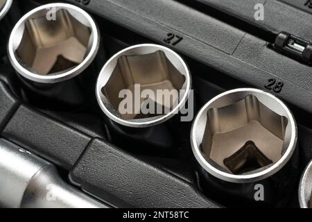 Kappenbuchsen zum Lösen von Muttern, die in einer Reihe in einer Box für Handwerkzeuge liegen. Schließen. Stockfoto