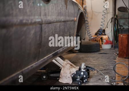 Autobremsteil in der Garage, Autobremsscheibe ohne Räder. Aktuelle Fahrzeugreparatur Stockfoto