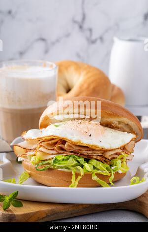 Bagel mit Frischkäse, geschredderter Salat, truthahnscheiben und Spiegelei, Frühstückssandwich-Idee Stockfoto