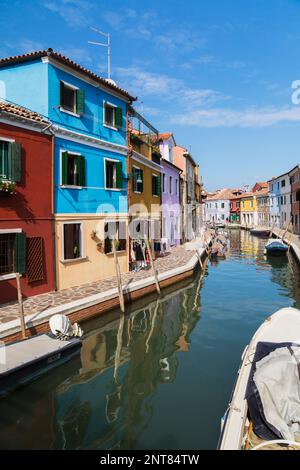 Festgemachte Boote auf dem Kanal, gesäumt mit bunten Häusern und Geschäften, Burano Island, Venetian Lagoon, Venedig, Venetien, Italien. Stockfoto