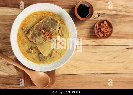 Top View Kari oder Gulai IGA Kambing oder ist Indonesien traditionelle Mutton Ribs Curry Suppe, reichhaltiger Geschmack und Gewürz für Eid al Adha Menü. Bereich für Text kopieren Stockfoto