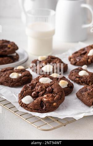 Doppelte Schokoladenkekse mit kleinen Marshmallows auf Pergament auf einem Kühlregal Stockfoto