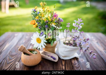 Leinenbeutel mit Salbeiblüten und orangefarbenen Calendula officinalis Heilkräutern in der Nähe des Mörtels. Beutel mit getrockneten Kräutern. Weichzeichner. Stockfoto