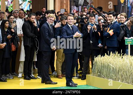 Der französische Präsident Emmanuel Macron begrüßt das Publikum mit Journalisten, die am 25. Februar 2023 in Paris, Frankreich, mit Fernsehkameras zusammen mit Minister Marc Fesneau zu seiner Linken anlässlich der 59. Ausgabe der Internationalen Landwirtschaftsmesse („Salon de l'Agriculture“) in Paris, vertreten waren. Foto: Victor Joly/ABACAPRESS.COM Stockfoto