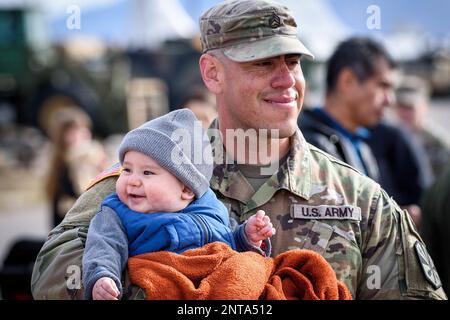 Tucson, Arizona, USA. 17. Februar 2023. Edgar Soto, Stabschef der Arizona Army National Guard, von der 860. Military Police Company, verbringt Zeit mit seinem 7 Monate alten Sohn Ezekiel nach einer Abschiedszeremonie für seine Einheit am 17. Februar 2023 im Valencia Armory in Tucson, Arizona Staff Sgt. Edgar und etwa 65 weitere Soldaten der Kompanie 860. MP, 850. Bataillon, sollen für 9 Monate nach Kuwait zur Unterstützung der Operation Spartan Shield entsandt werden. Kredit: USA Army/ZUMA Press Wire Service/ZUMAPRESS.com/Alamy Live News Stockfoto