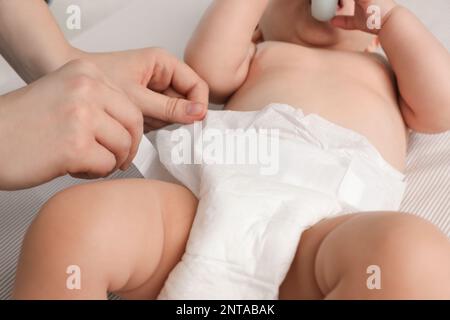 Mutter, die die Windel des Babys wechselt, auf dem Bett, schließen Stockfoto