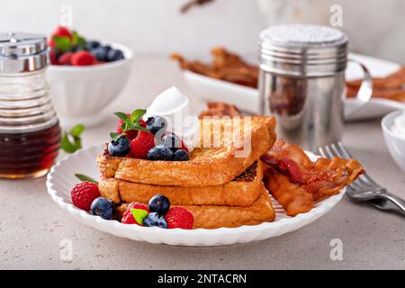 Klassischer französischer Toast mit Speck und frischen Beeren garniert mit Schlagsahne Stockfoto