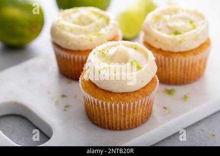 Kokosnuss- und Limetten-Cupcakes auf dem Servierbrett, Limettenkuchen-Dessert Stockfoto